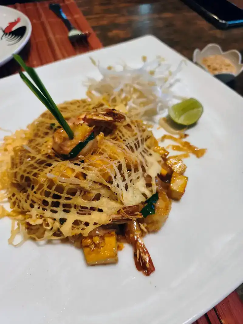 Noodles wrapped in a lacy egg net, with prawns and tofu