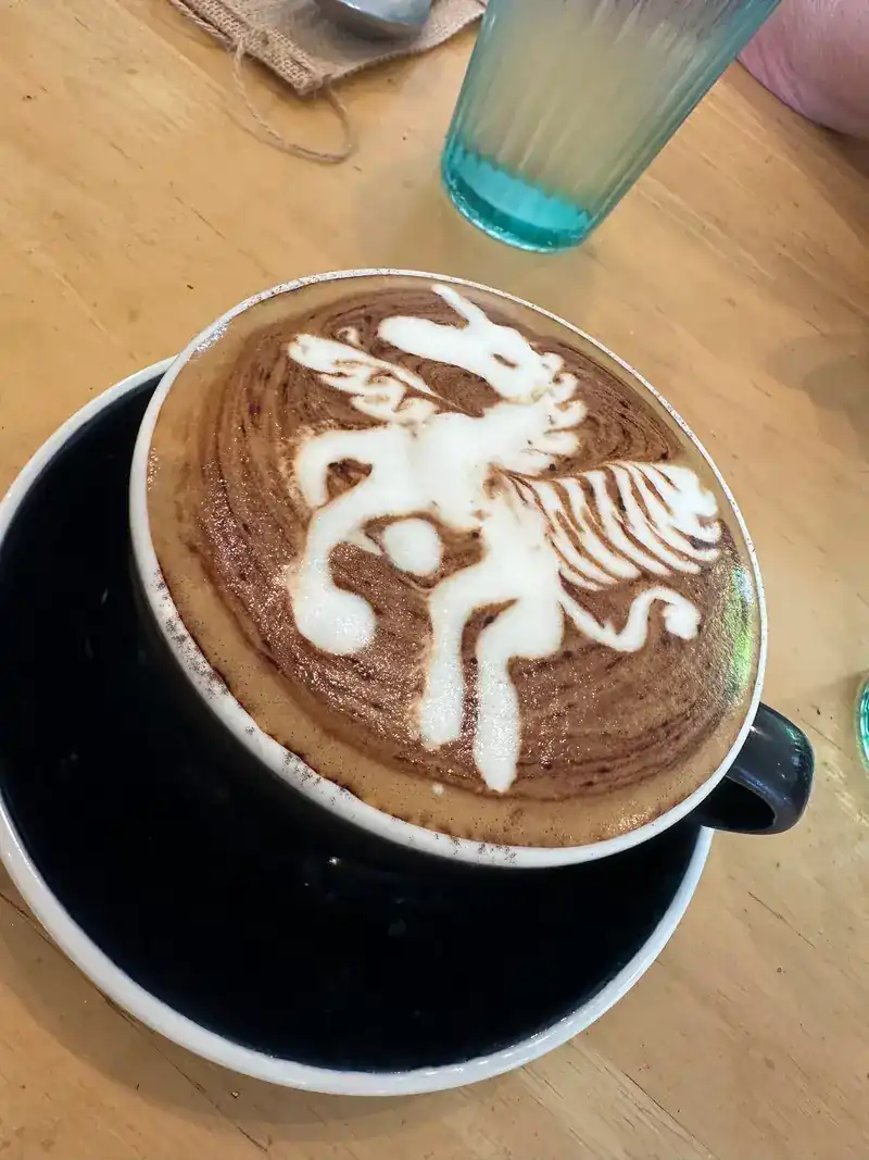 A cup with latte art of a winged creature