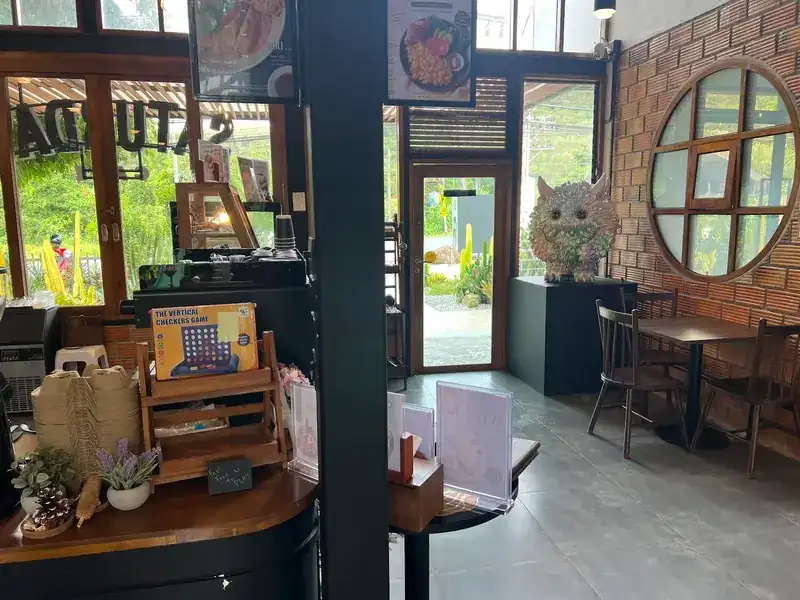 Inside: a brick wall, a round window and dark wooden tables