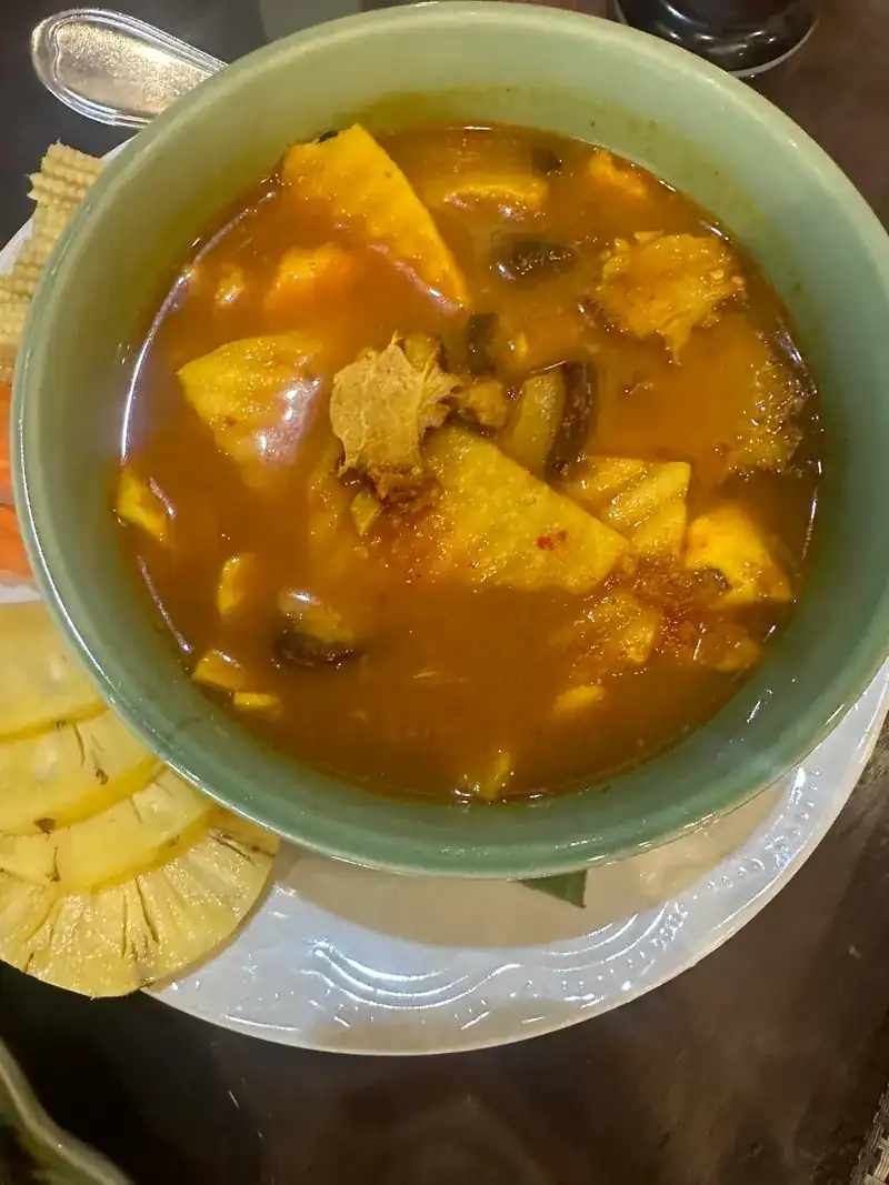 A bowl of curry with pineapple