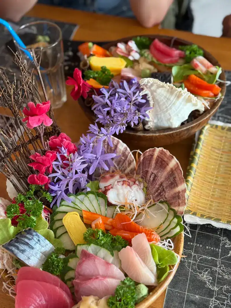 Sashimi platter with scallop shells, flowers and fresh fish