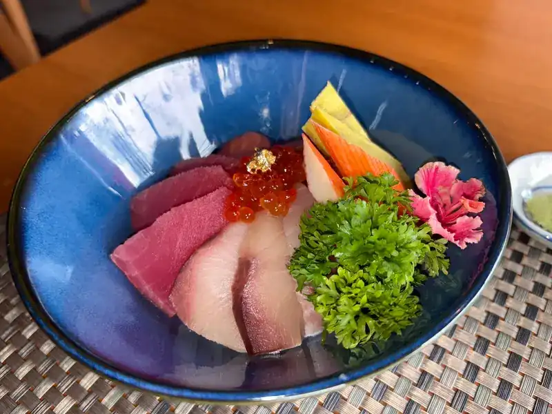 Sliced raw fish, salmon roe and tamago in a blue bowl / ปลาดิบหั่นชิ้น ไข่ปลาแซลมอน และไข่หวานในชามสีน้ำเงิน