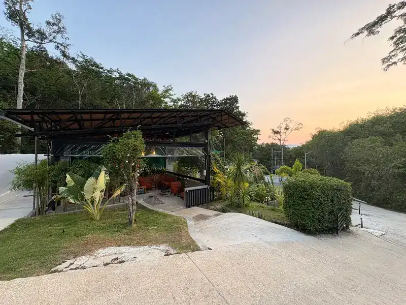 The café at dusk, seen from the driveway, with forest behind. ร้านยามพลบค่ำ มองจากทางเข้า มีป่าอยู่ด้านหลัง