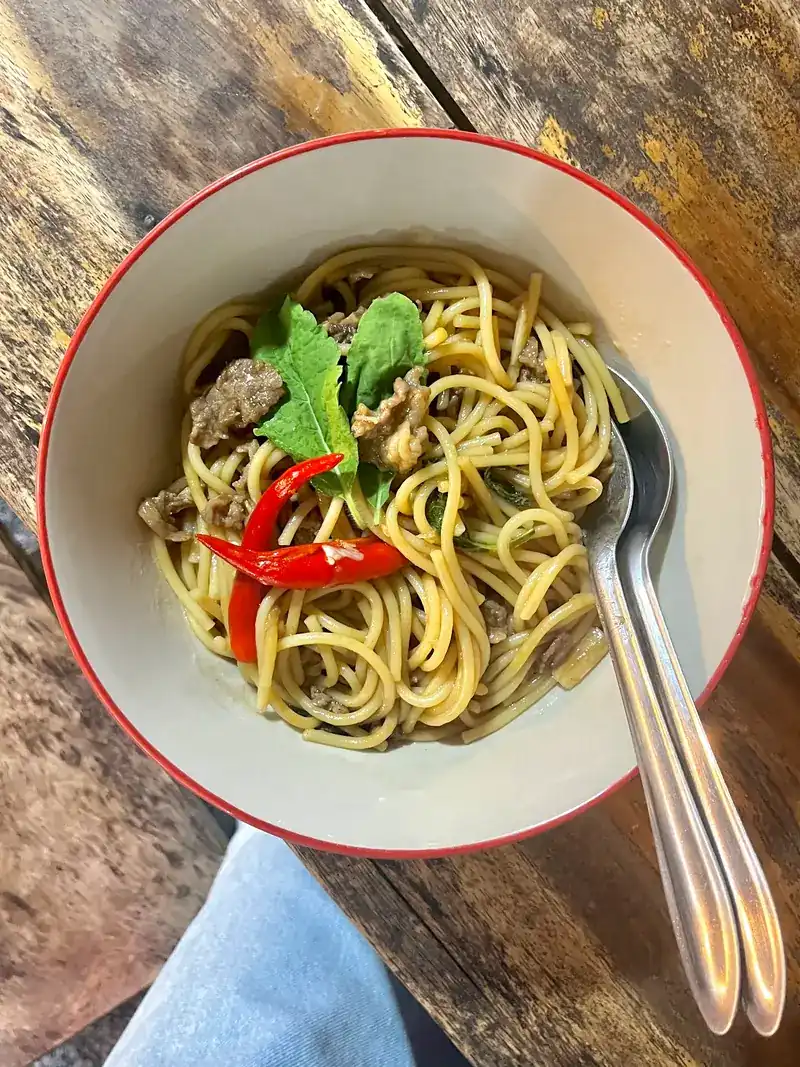 Stir-fried noodles with meat, red chilli and fresh herbs