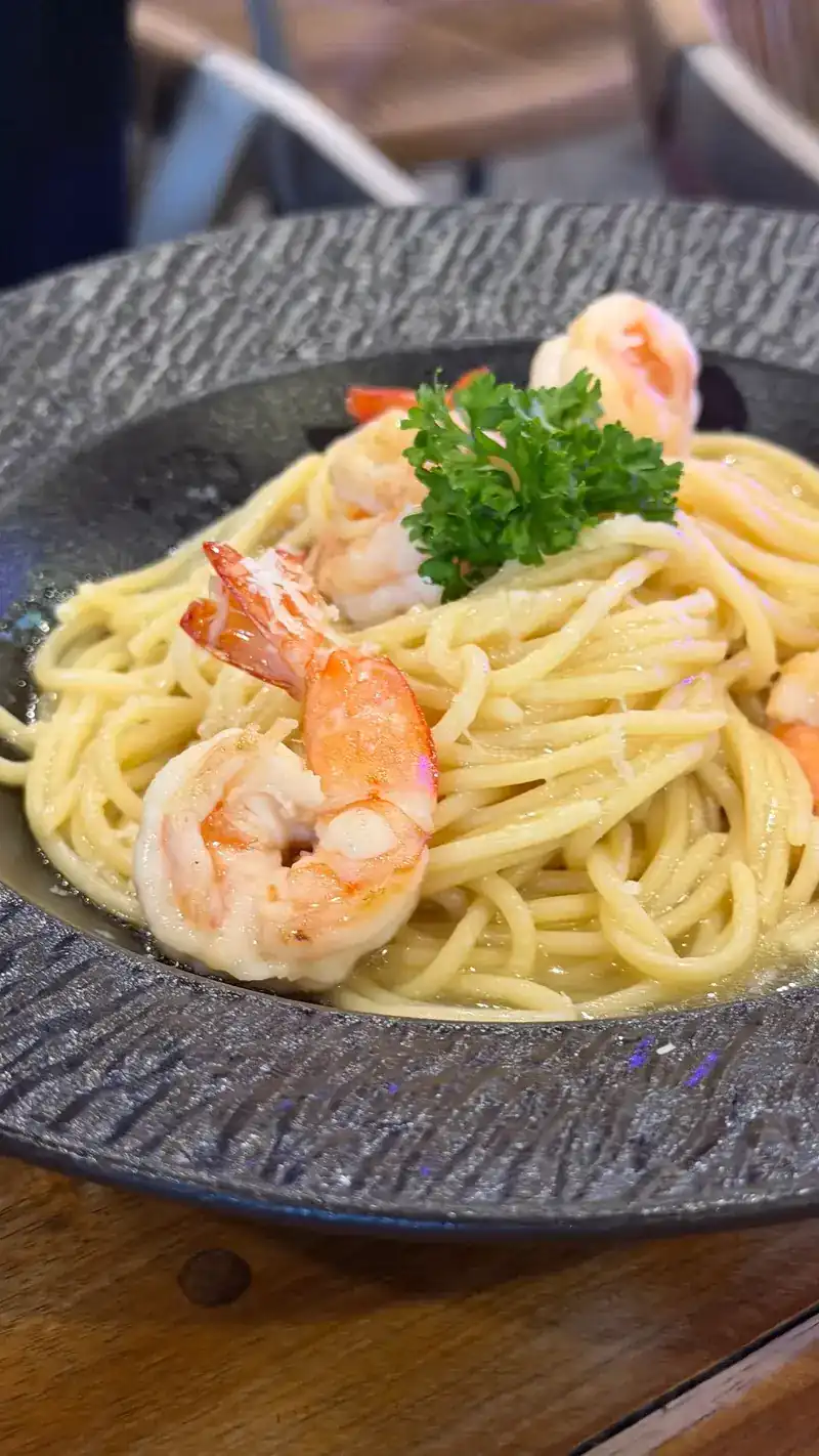 Spaghetti with prawns and parsley in a dark bowl / สปาเก็ตตี้กุ้งโรยพาร์สลีย์ในจานสีเข้ม