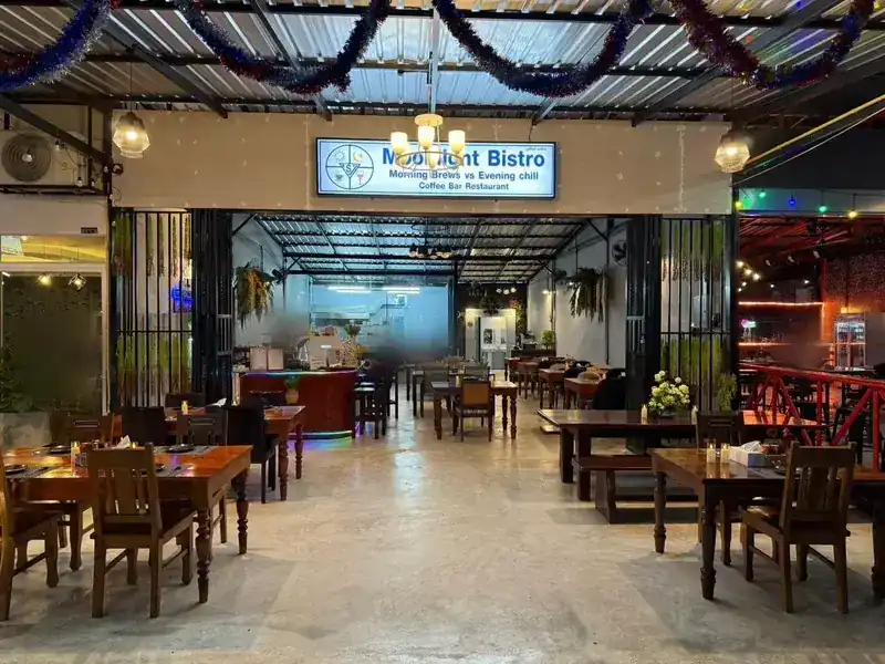 The dining room under the Moonlight Bistro sign, with the lamps lit