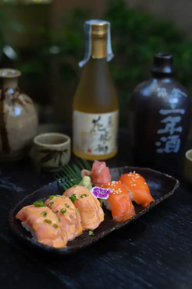 Salmon nigiri sushi on a dark stoneware plate