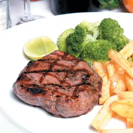 Grilled fillet steak with broccoli, fries and lemon