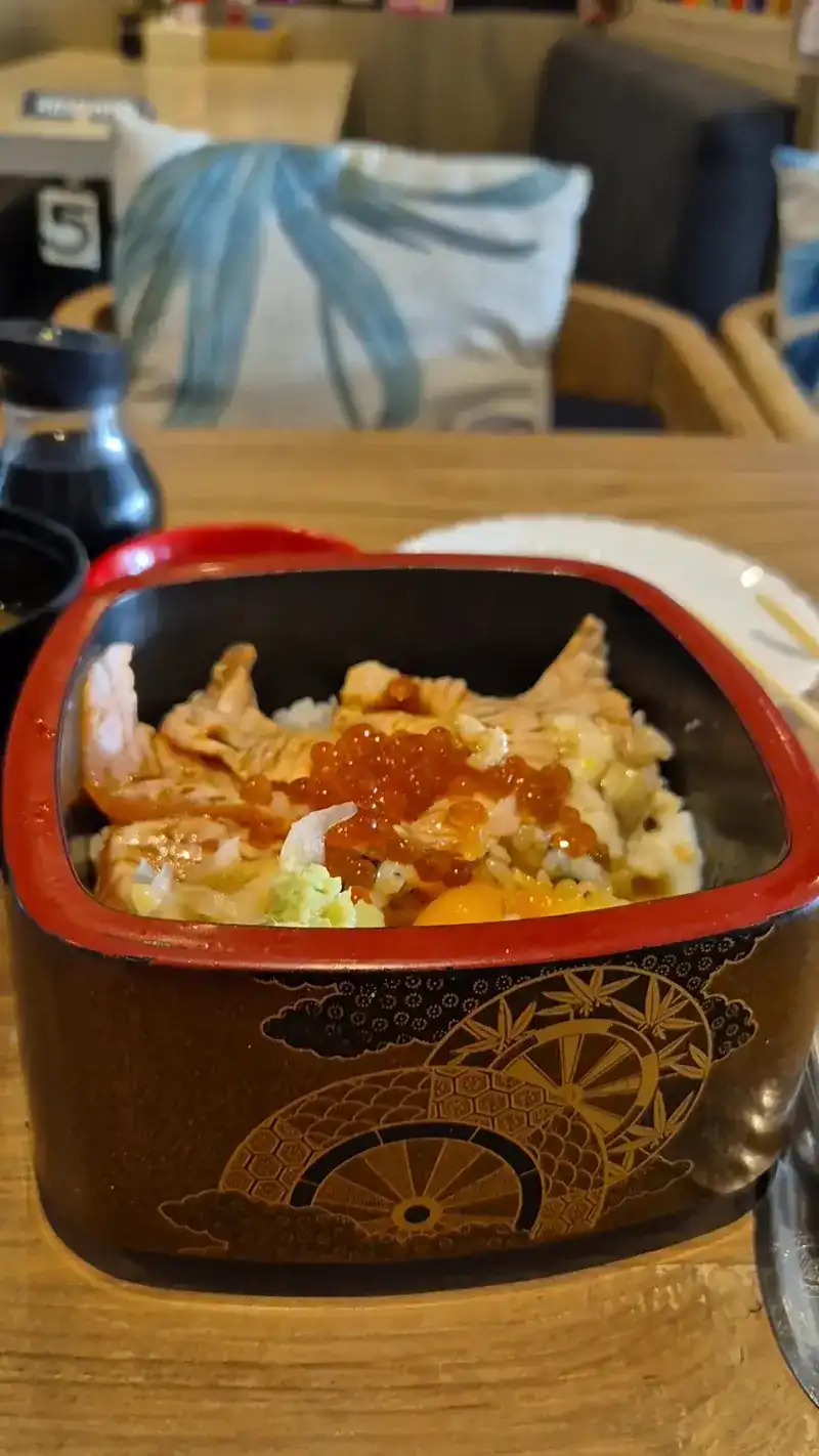 Rice bowl topped with salmon and salmon roe in a lacquer box