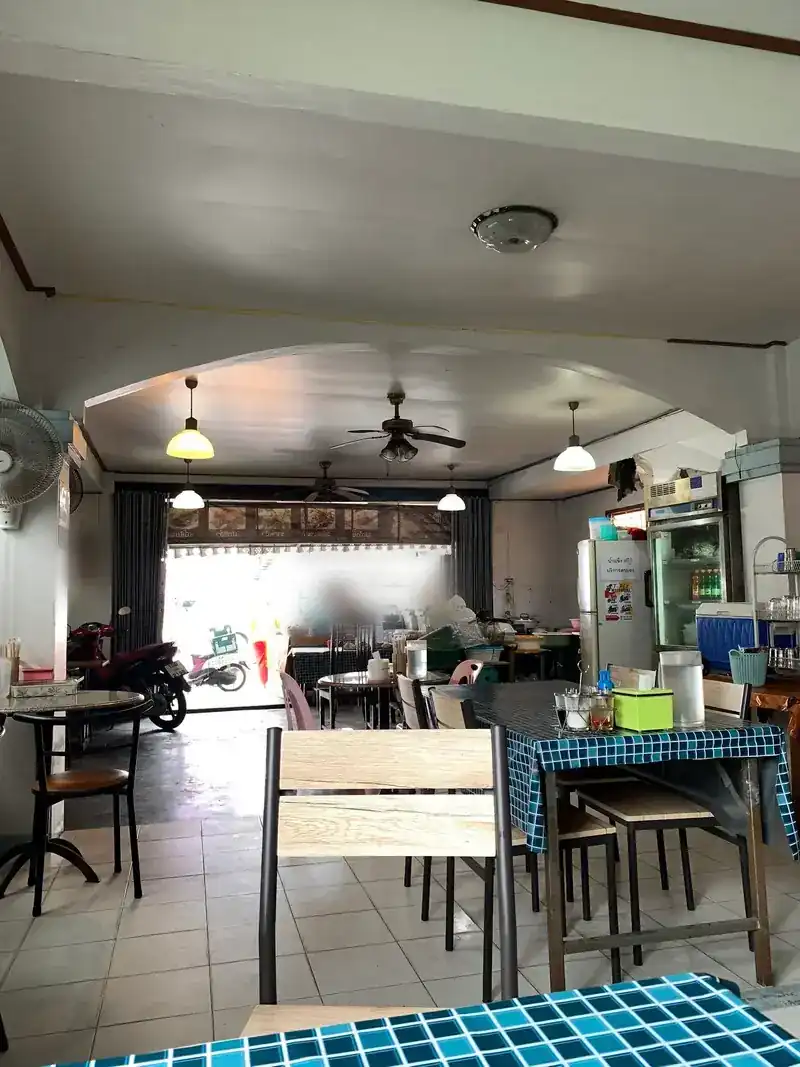 Inside the shop: ceiling fans, an open front and tables in teal tile oilcloth