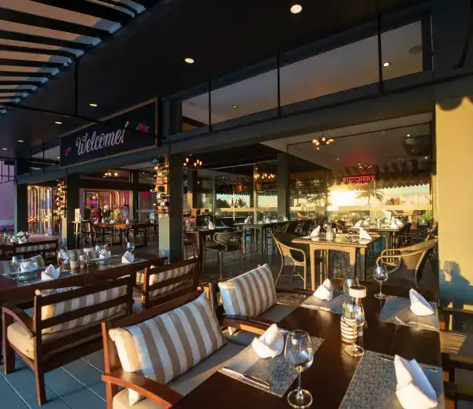Terrace tables with striped cushions in late sun