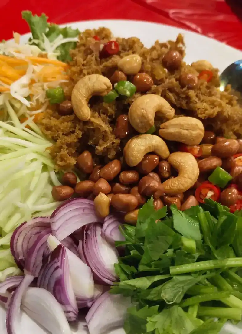 A crispy shredded salad with cashews, peanuts, red onion and fresh herbs