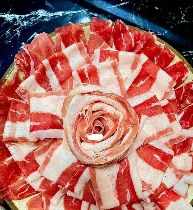 Sliced beef arranged as a rose on a round plate