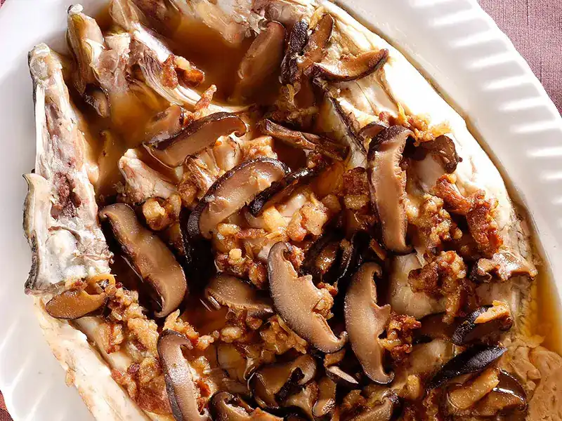 Steamed fish topped with black mushrooms and minced pork