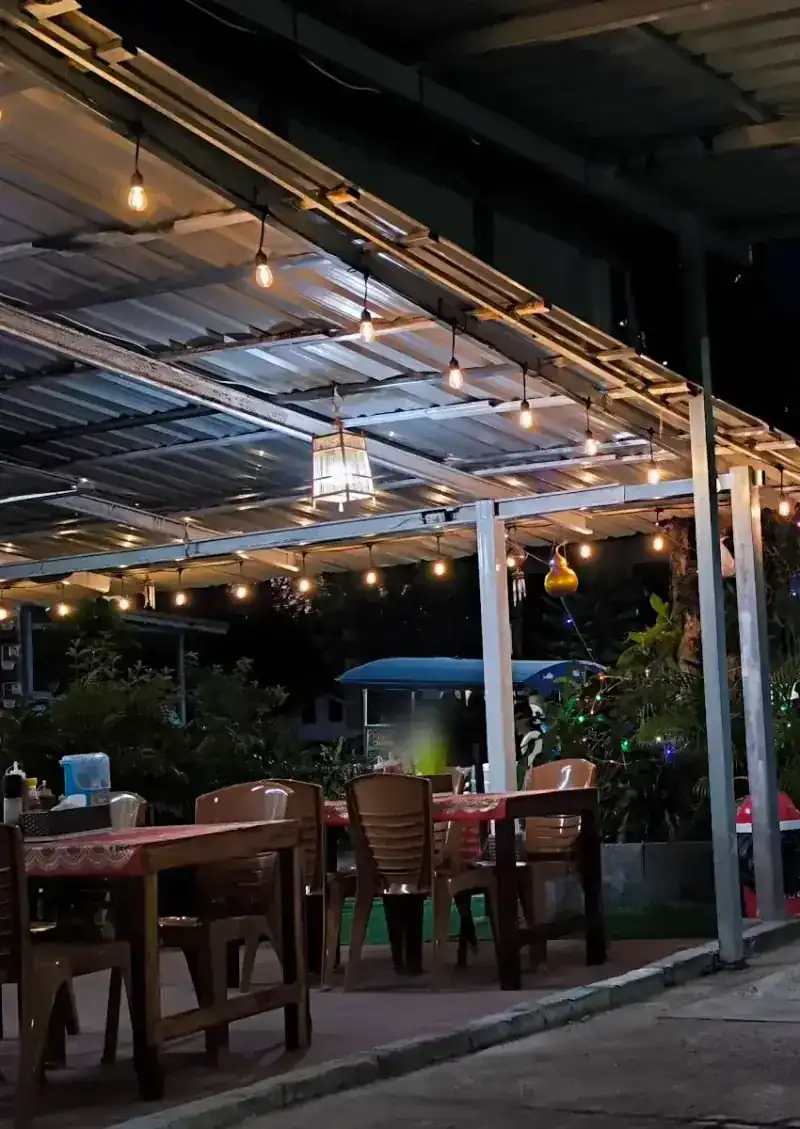 The open-air terrace at dusk, with string lights under the roof