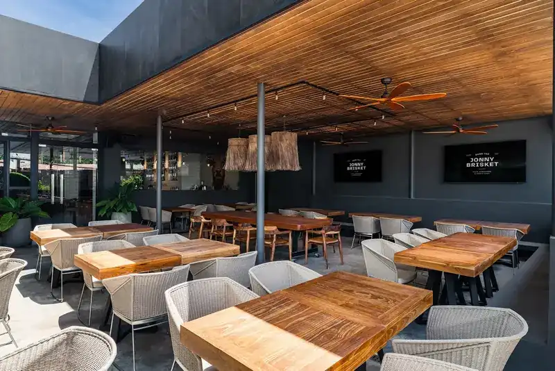The terrace under a wooden ceiling with wicker chairs and ceiling fans