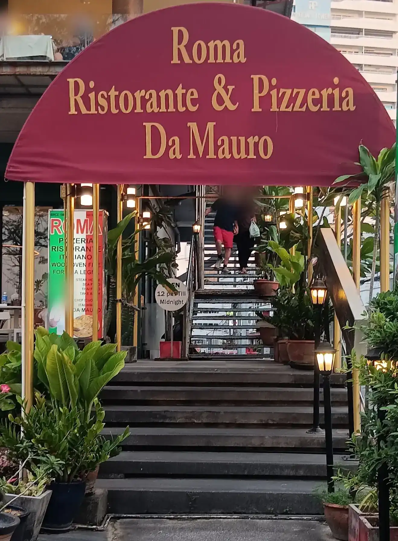 The burgundy awning of Roma Ristorante & Pizzeria Da Mauro over the stairs up to the restaurant