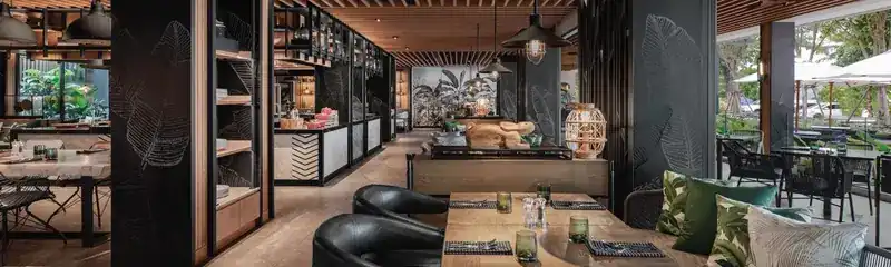 Dining room with black leaf-engraved columns, timber ceiling and set tables