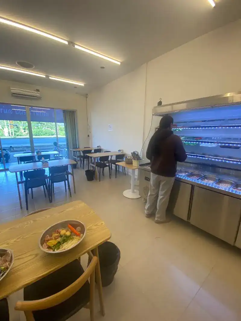 Inside the shop: wooden tables, and the chilled bar along the wall