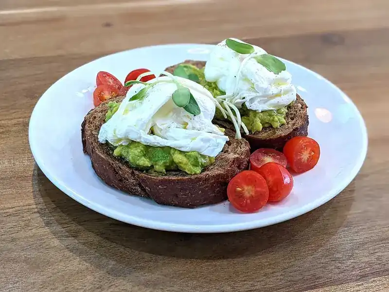 Avocado toast with poached eggs and cherry tomatoes