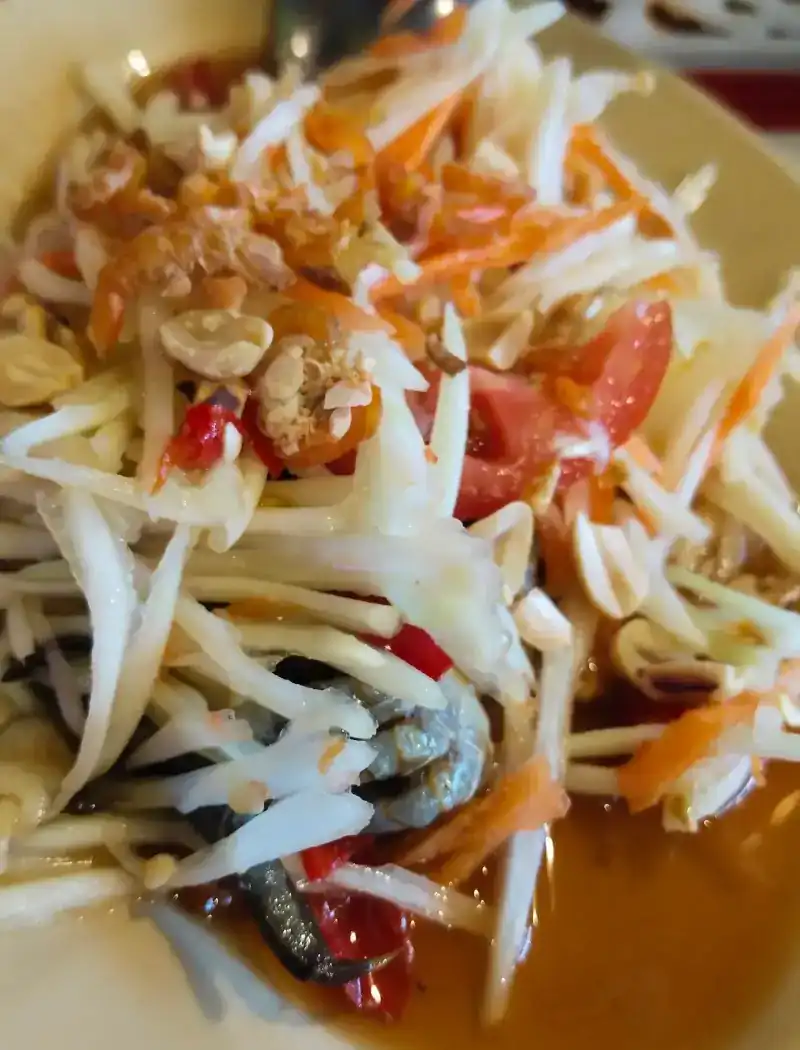 Papaya salad with tomato, peanuts and small crab in its dressing
