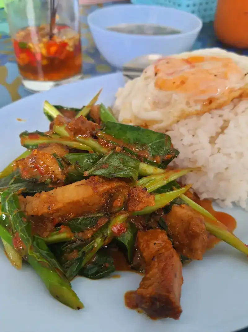 Pork belly stir-fried with greens in a red chilli sauce, with rice and a fried egg