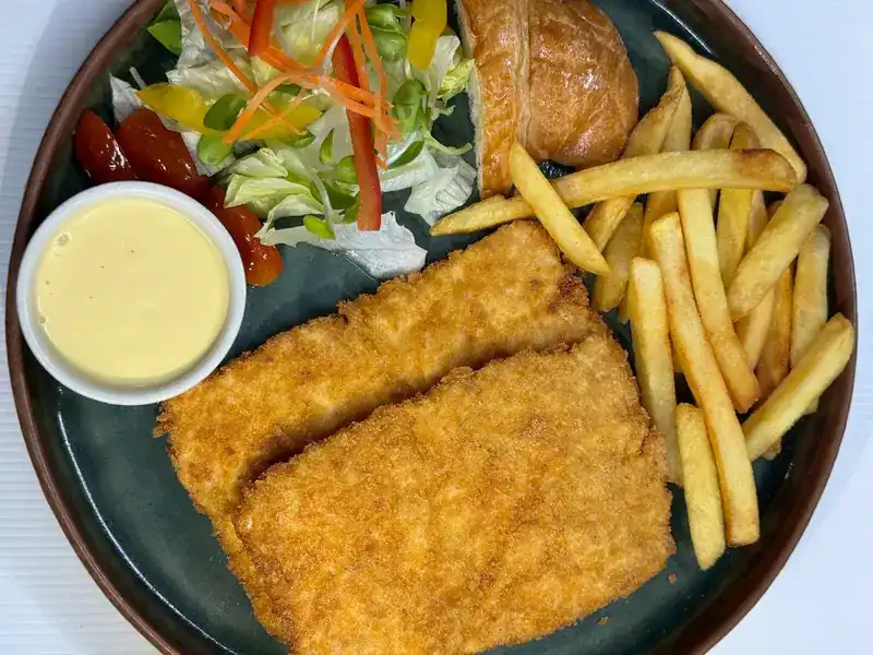 Two breaded fried fillets with fries, salad and a creamy dip