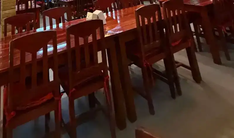 Red wooden chairs with red cushions along a glossy red table