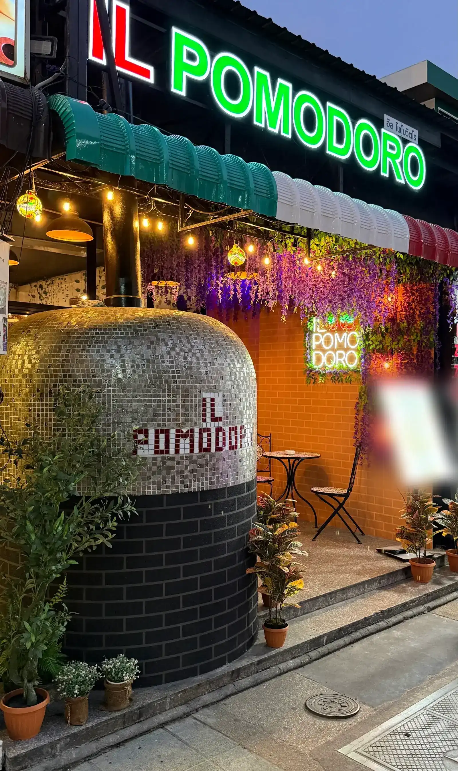 The silver mosaic pizza oven at the front of Il Pomodoro, under the green neon sign on Thaweewong Road