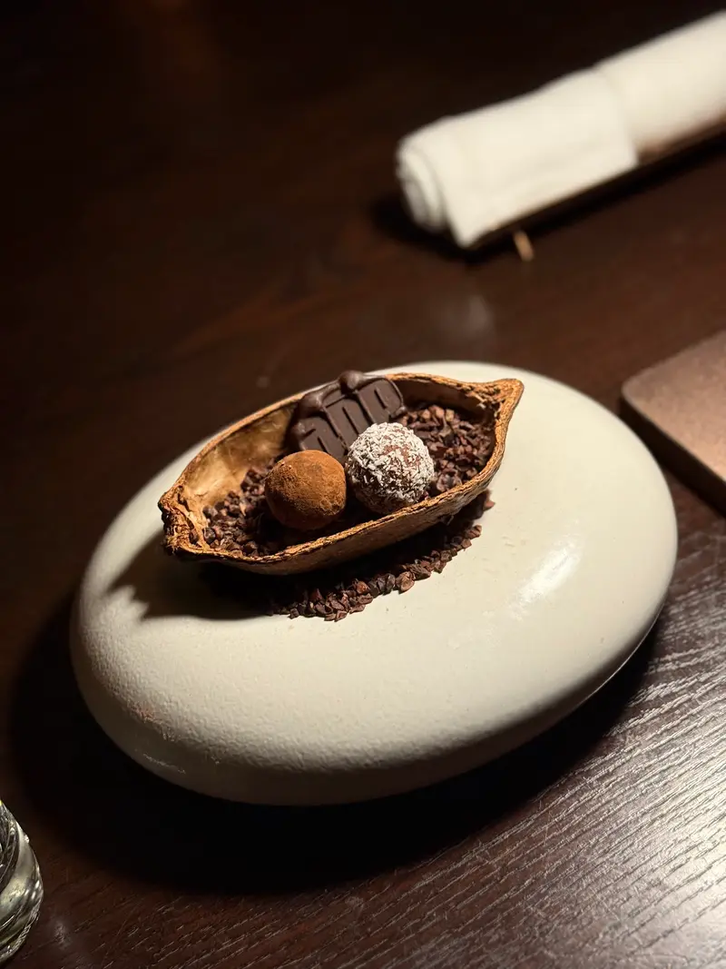 Chocolates in a cacao pod on a pale stone dish / ช็อกโกแลตในเปลือกฝักโกโก้บนจานหินสีอ่อน