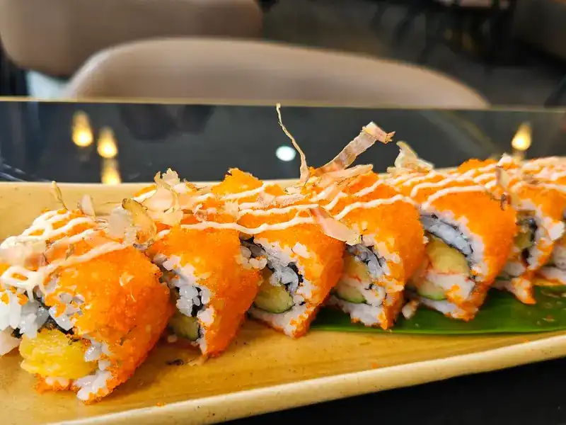 Rolls topped with orange fish roe, mayonnaise and bonito flakes