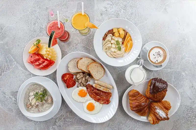 Breakfast spread: eggs and bacon, croissants, fruit, yoghurt bowl, rice soup, juices and coffee
