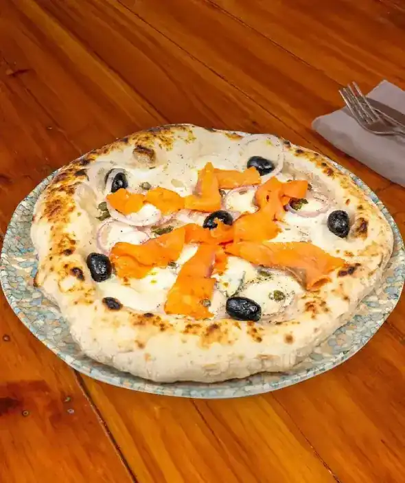White pizza with smoked salmon, red onion and black olives