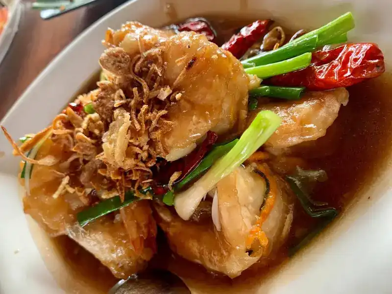 Prawns in a glossy brown sauce with dried chillies, spring onion and crisp fried shallots