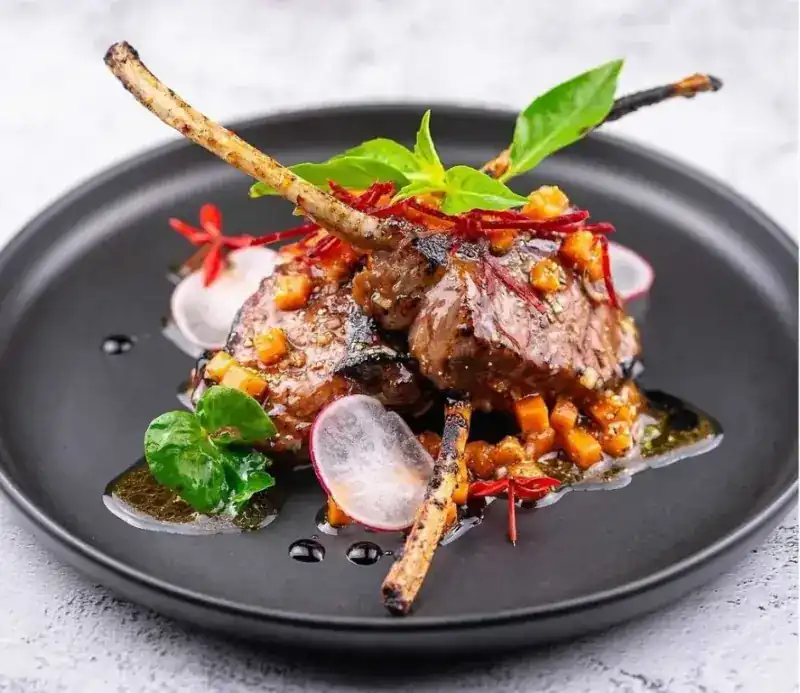 Lamb chops on a black plate