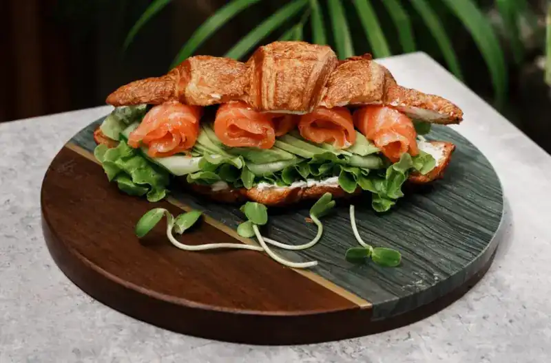 Croissant filled with salmon, avocado and salad