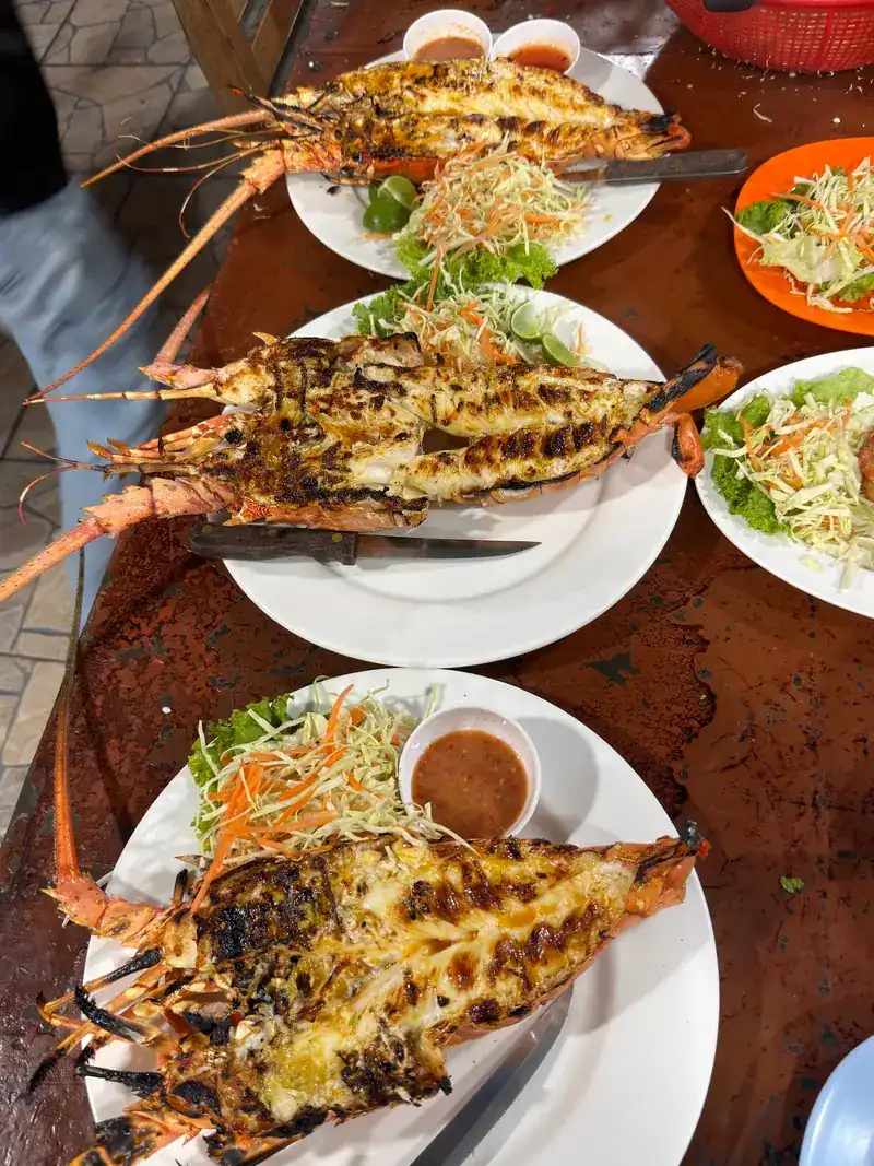 Three split lobsters off the grill on white plates