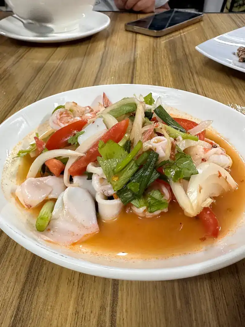 Spicy seafood salad with squid, prawns, tomato and spring onion