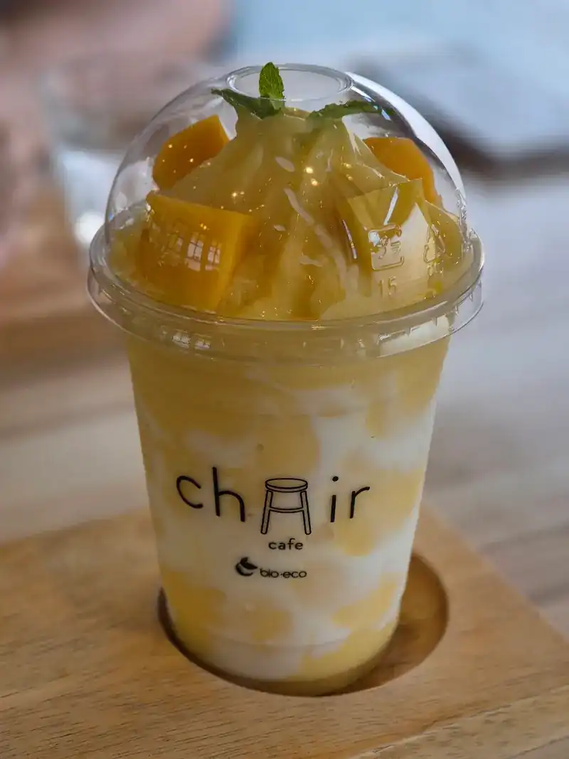 Mango smoothie topped with mango pieces and mint