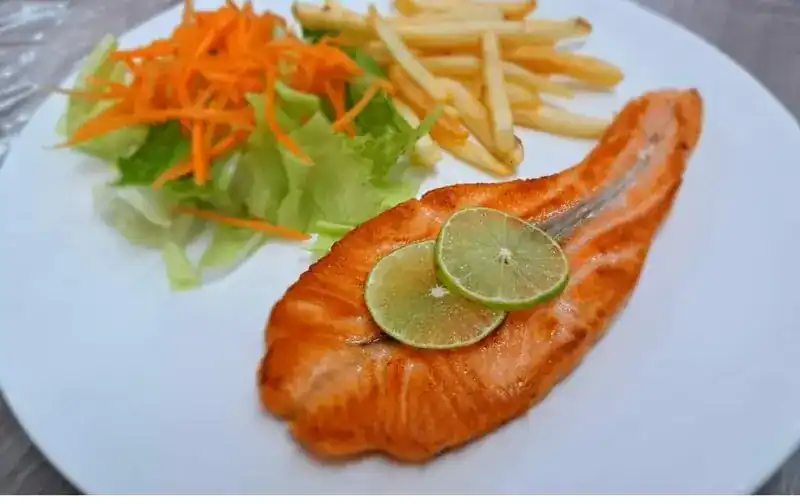 Salmon steak with lime, fries and salad