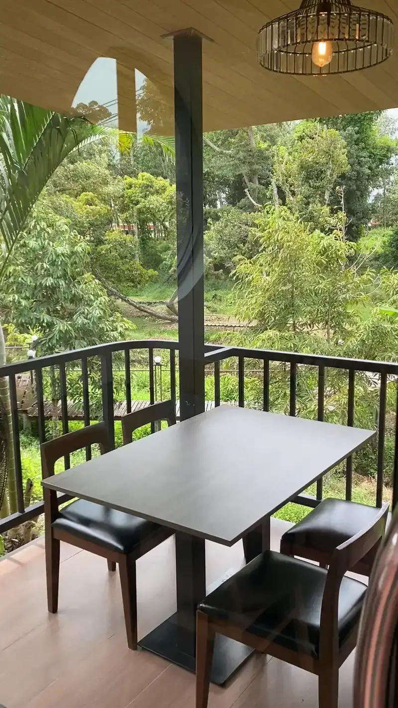 A table on the covered terrace, looking out over the garden / โต๊ะบนระเบียงที่มีหลังคา มองออกไปเห็นสวน