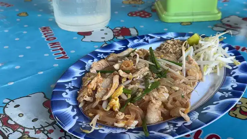 Pad thai with bean sprouts and lime on a blue patterned plate