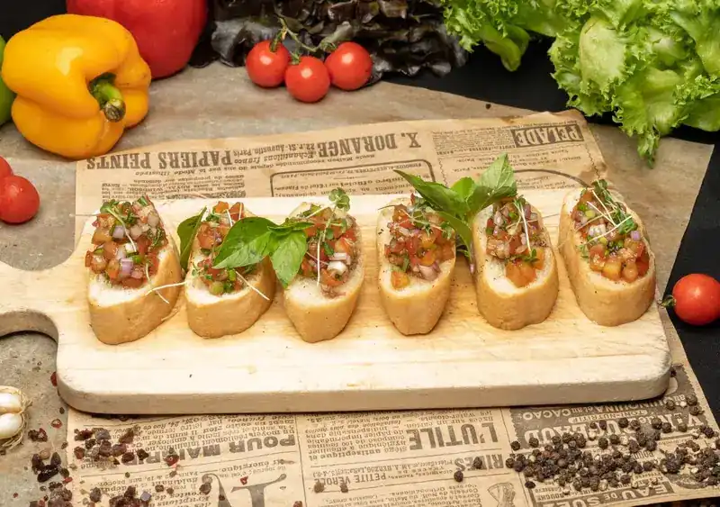 Six bruschetta with tomato and basil on a wooden board