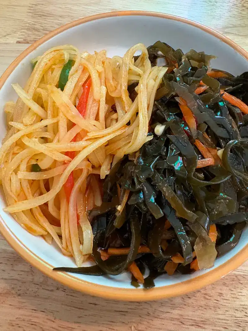 Cold shredded potato and seaweed with carrot in one bowl
