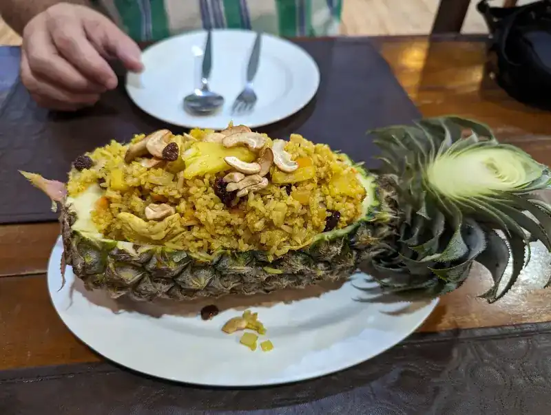Fried rice with cashews and raisins, served in a pineapple