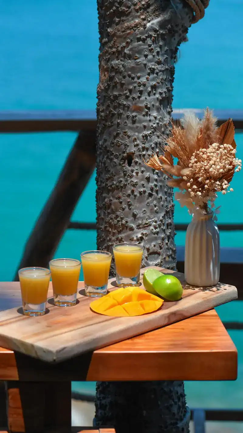 A wooden table on the terrace with turquoise sea behind it