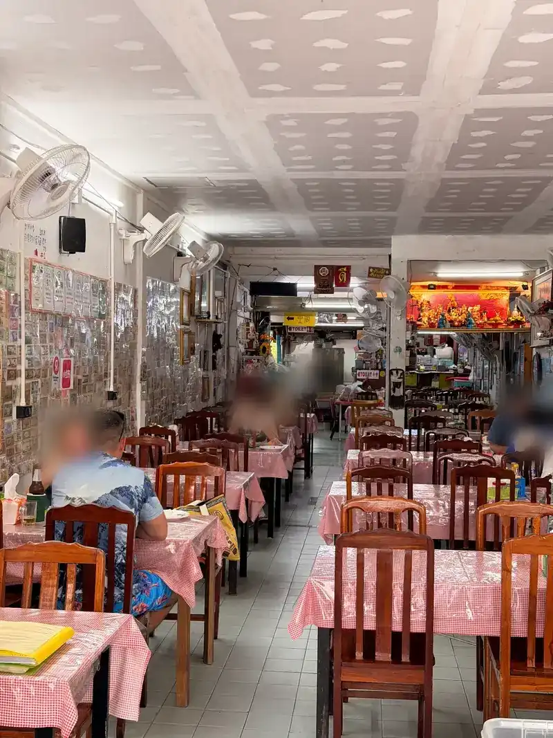 The long dining room with pink-checked tablecloths, wooden chairs and fans on the walls / ห้องอาหารยาว โต๊ะปูผ้าลายสก็อตสีชมพู เก้าอี้ไม้ และพัดลมติดผนัง