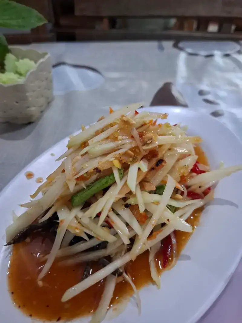 Green papaya salad on a white plate