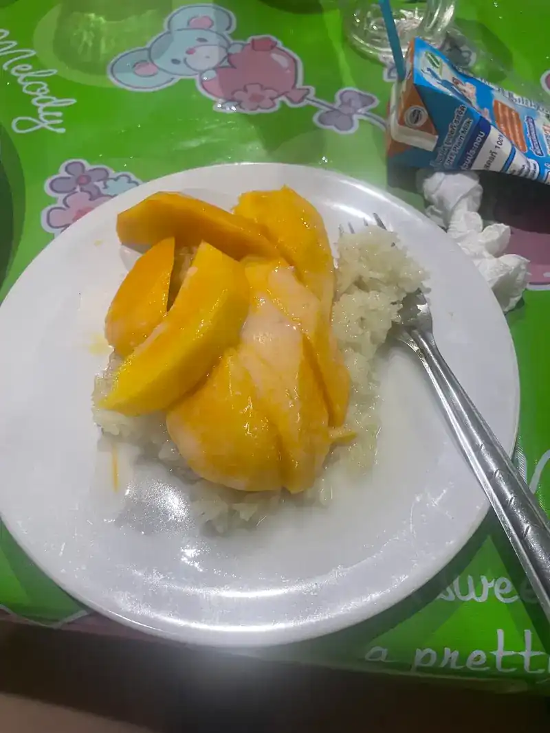 Mango with sticky rice on a green tablecloth / ข้าวเหนียวมะม่วง บนผ้าปูโต๊ะสีเขียว