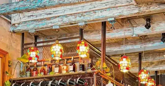 Stained glass lamps hanging from the whitewashed wooden beams above the bar